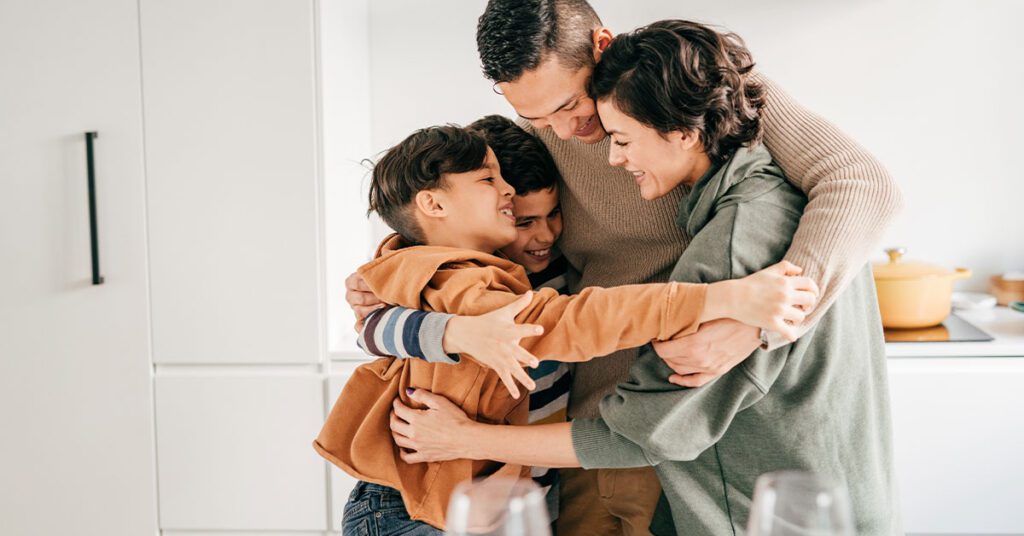 family with 2 kids hugging